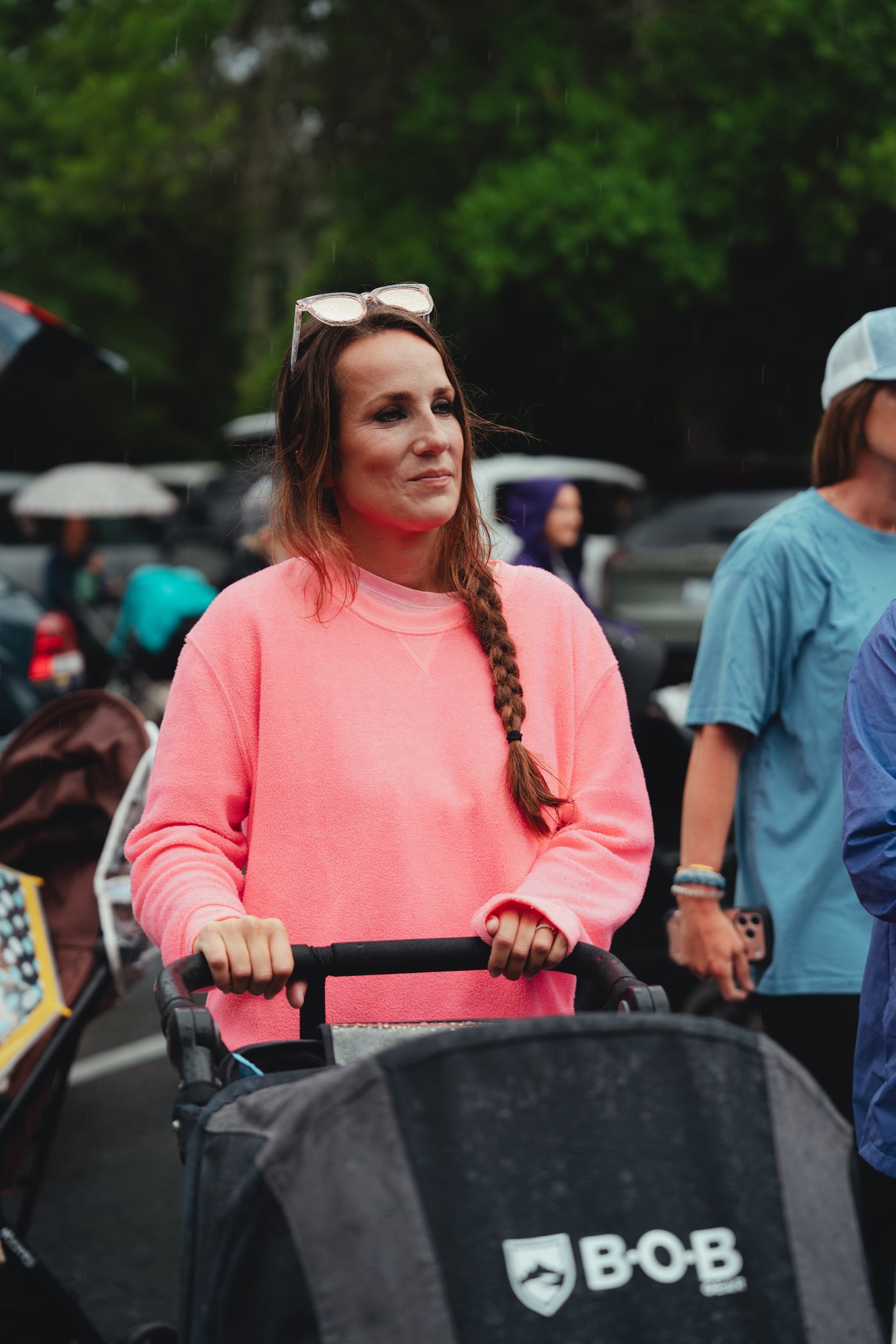 A mom in a pink sweatshirt with her BOB stroller at Babes & Barbells
